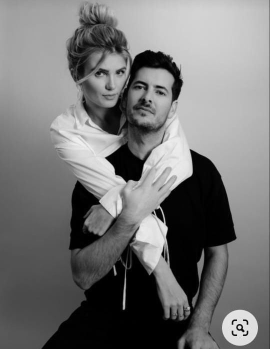 a man and woman are posing for a black and white photo with their arms around each other