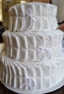 a three tiered cake with white ruffles on it