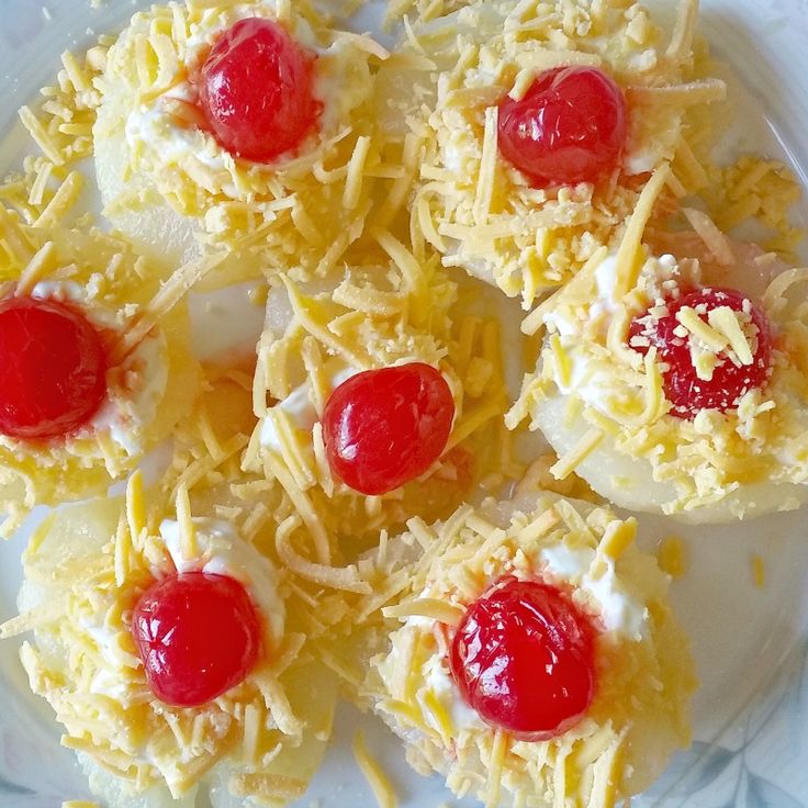 small pastries with cherries and cheese on a plate