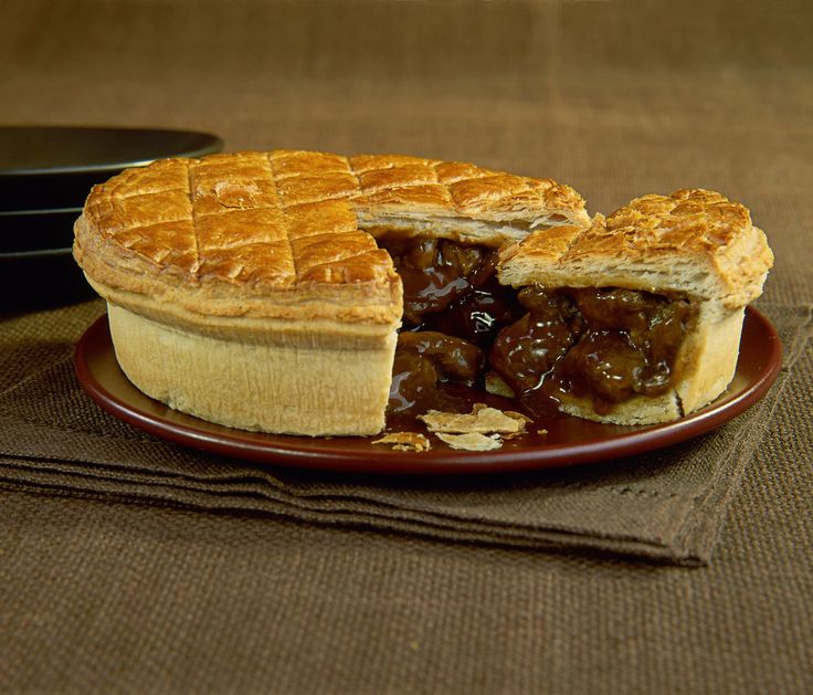 there is a pie on the plate with two slices cut out and ready to be eaten