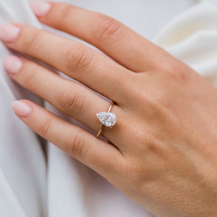 a woman's hand with a diamond ring on it