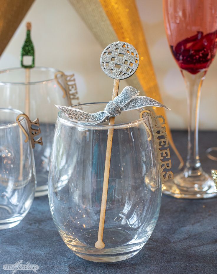 there are three wine glasses on the table and one is holding a candy cane in it