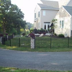 a black fence in front of a white house