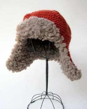 a red and white hat on top of a metal stand with a wire rack underneath it