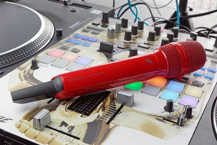 a red microphone sitting on top of a dj's turntable