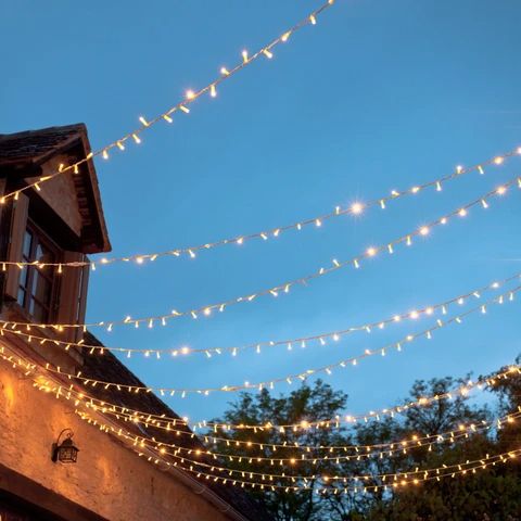 there are many lights strung from the roof and on the building's side window