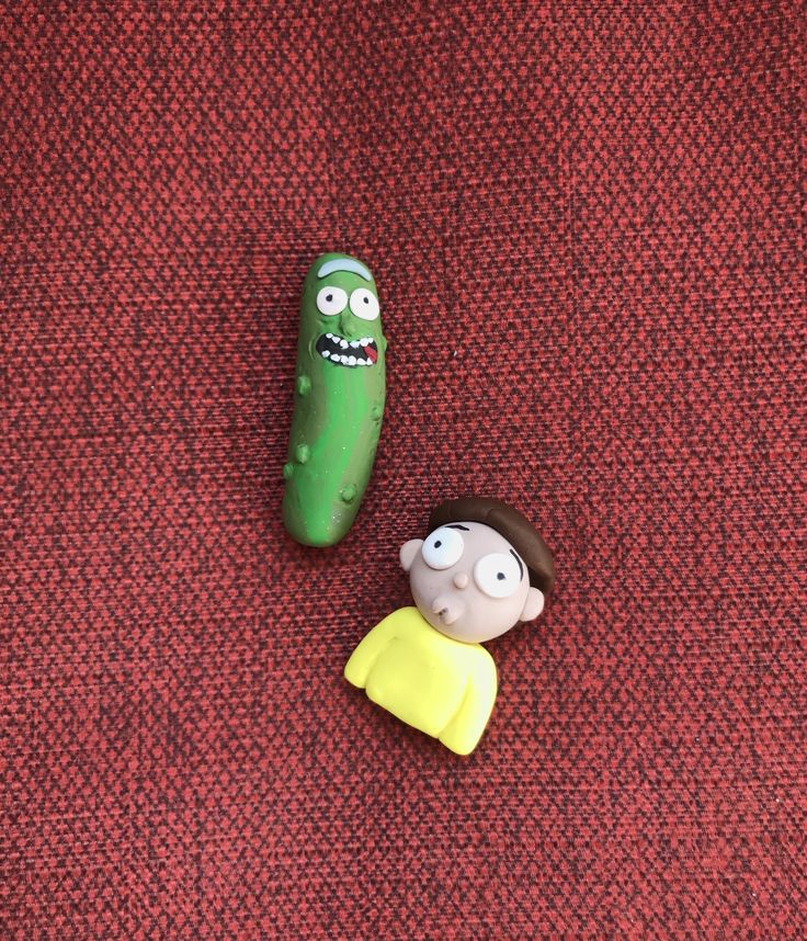 two toy figures sitting on top of a red carpet next to each other in the shape of a pickle