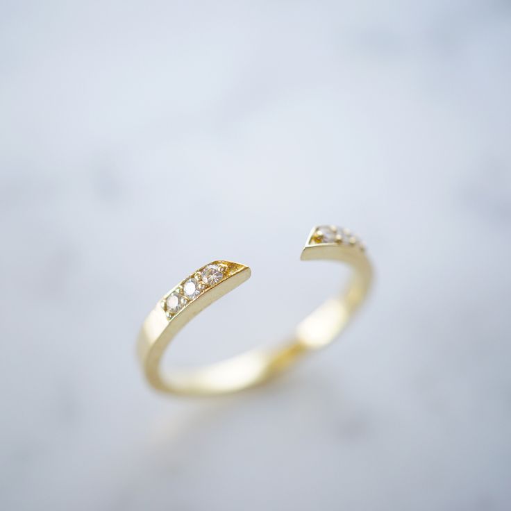 a gold ring with two diamonds on it