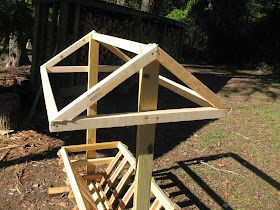 a wooden structure sitting on top of a grass covered field