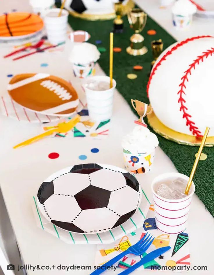 a table set up for a sports themed birthday party with plates, cups and napkins