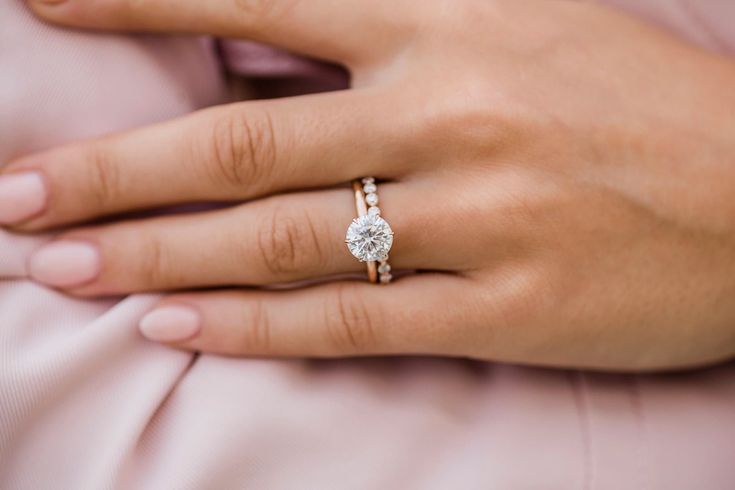 a woman's hand with a diamond ring on it