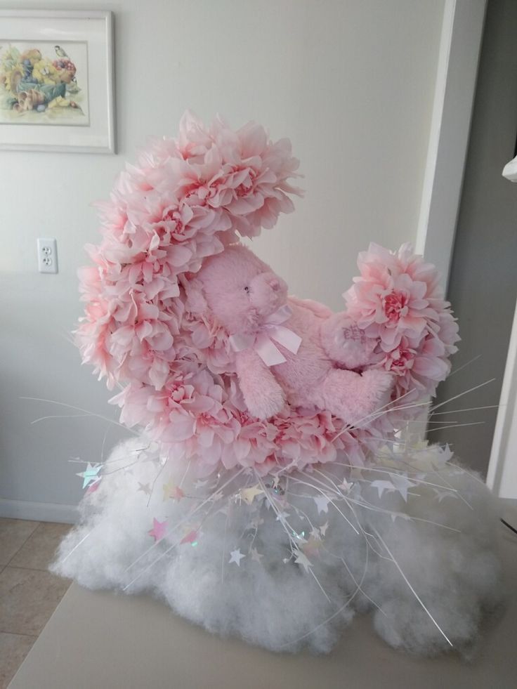 a pink teddy bear sitting on top of fluffy white clouds in a room next to a wall