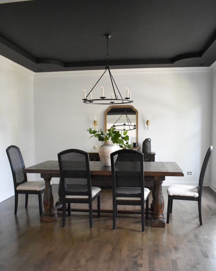 a dining room table with four chairs and a potted plant on top of it