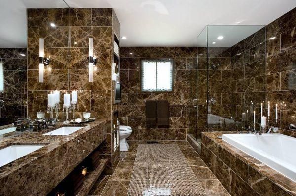 a bathroom with marble walls and flooring, mirrors on the wall, two sinks in the middle