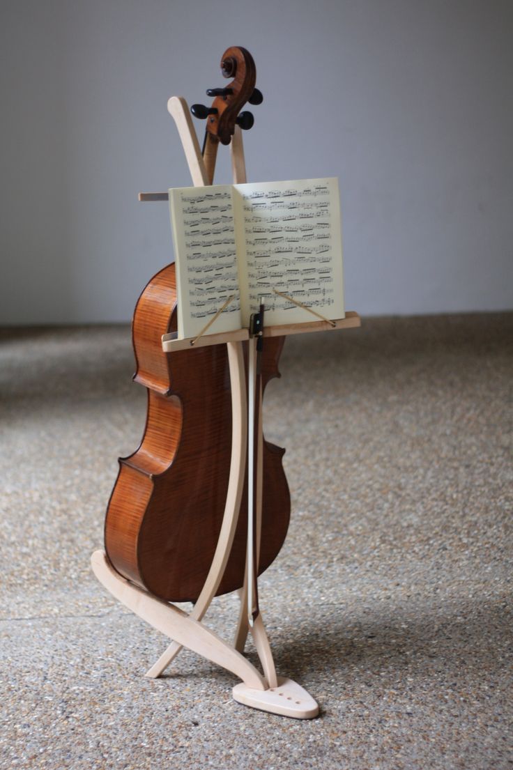 an old violin is sitting on a stand with sheet music in it's back