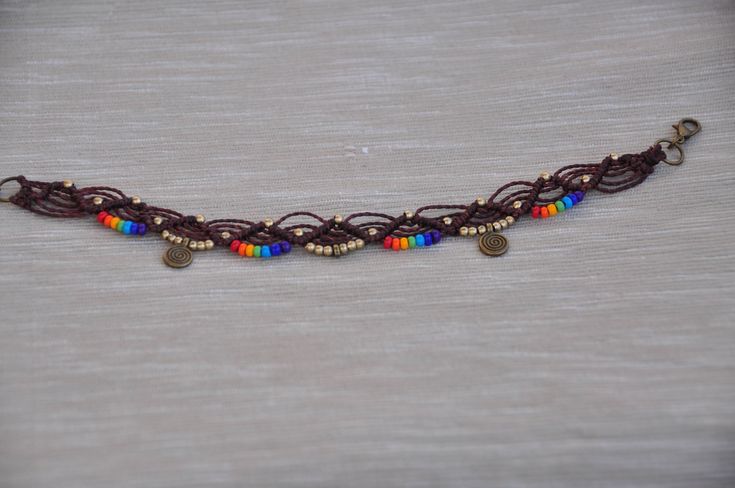 This listing is for one anklet. Beautiful macrame anklet. You can wear it alone or in combination with the barefoot sandals available in my shop (picture 2, 3 and 6) https://www.etsy.com/listing/216695617/shanti-rainbow-mandala-barefoot-sandals?ga_search_query=shanti&ref=shop_items_search_1 This anklet is made with waxed polyester cord, antique bronze beads, antique bronze spiral charms and czech seed seed beads. They close with a lobster claw and on the other side a small chain allows to ad Bohemian Rainbow Beaded Bracelets, Hippie Beaded Ankle Wrap Anklets, Adjustable Hippie Choker For Festivals, Rainbow Adjustable Choker For Festivals, Rainbow Adjustable Choker For Festival, Adjustable Ankle Wrap Anklets For Festivals, Brown Bracelets For Summer Festival, Bohemian Tiny Beads Friendship Bracelets For Festivals, Hippie Ankle Wrap Anklets For Festival