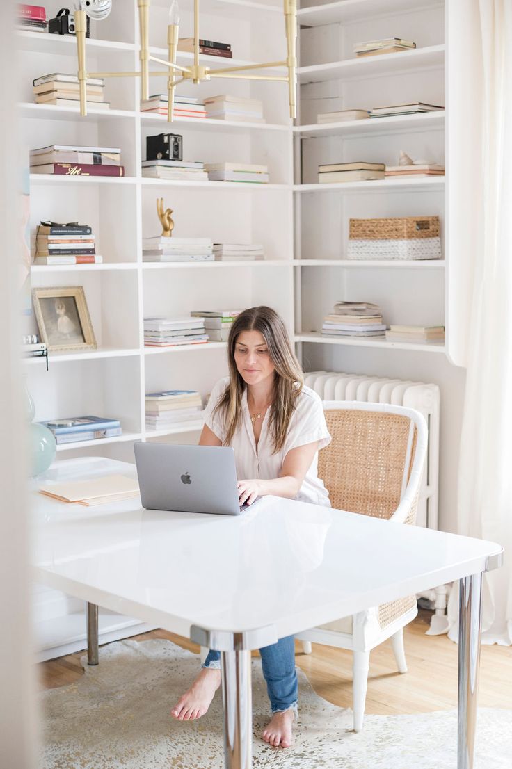 a woman sitting at a table with a laptop