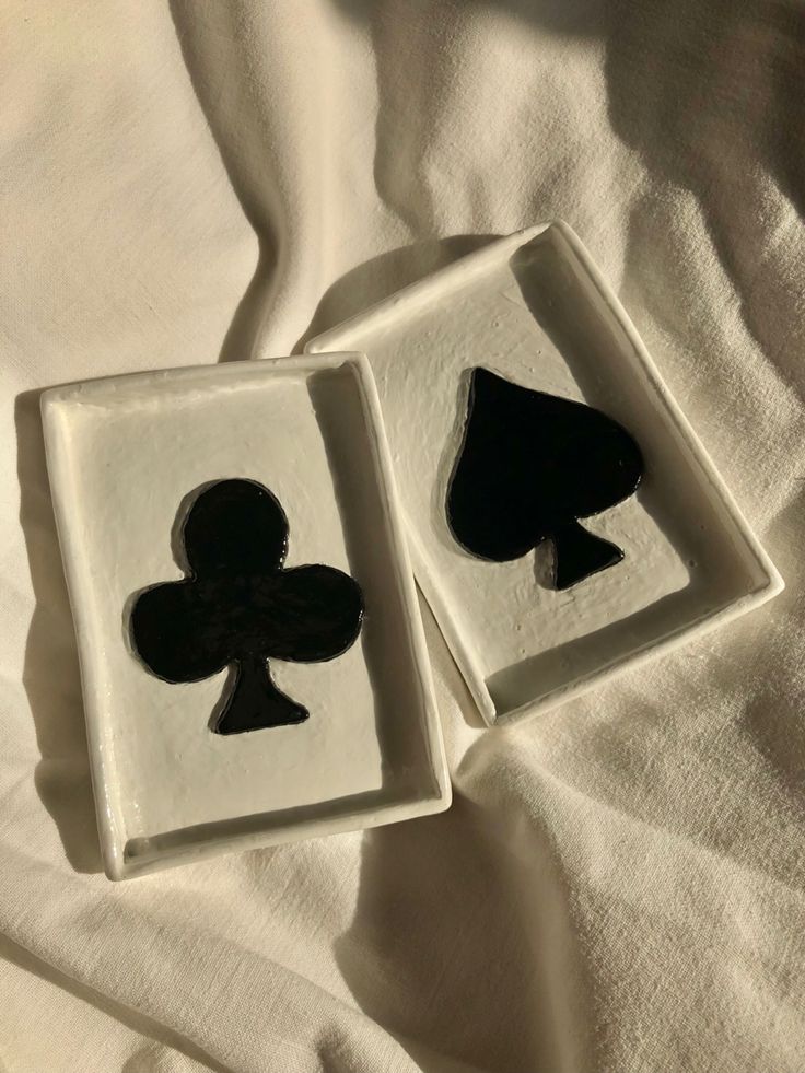 two black and white playing cards on a bed