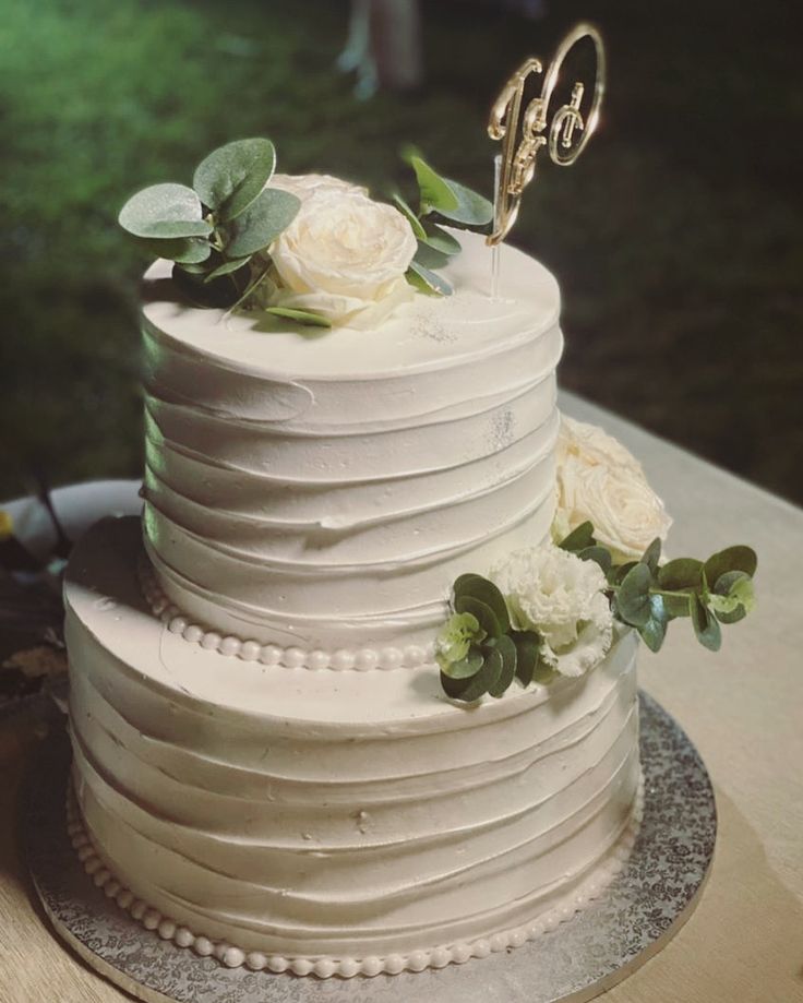 a white wedding cake with flowers on top and the number 50 on it's side