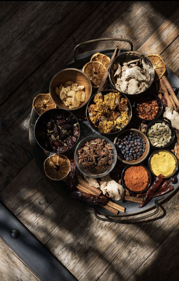 an assortment of spices and condiments arranged in a circle on a wooden table