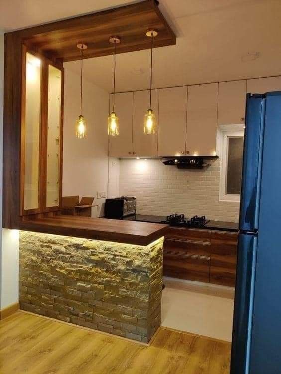 a kitchen with wooden flooring and white walls next to a blue refrigerator freezer