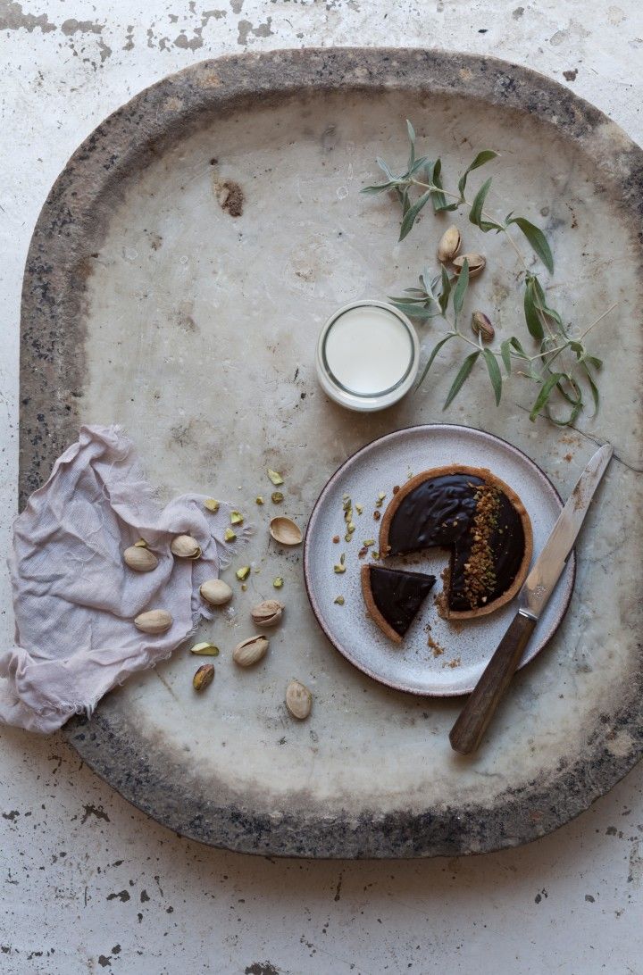 a plate with a piece of cake on top of it next to a glass of milk