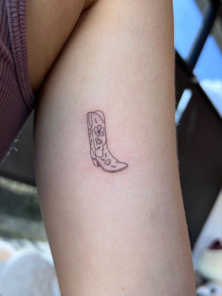 a small tattoo on the thigh of a woman's leg with a cowboy boot