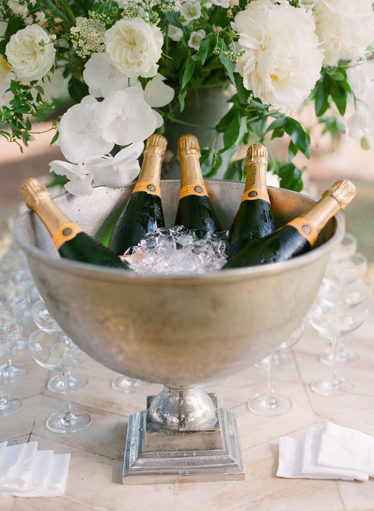 champagne bottles in a silver bowl with white flowers