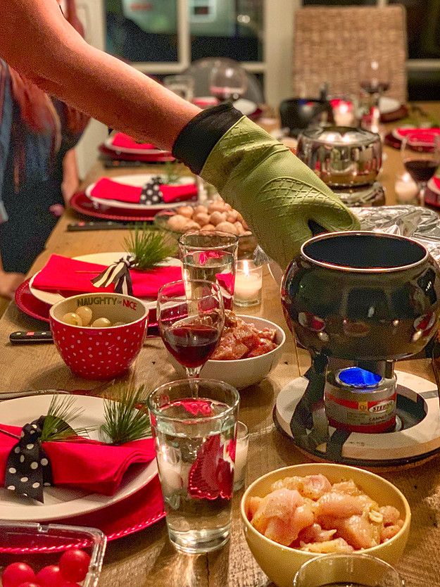 the table is set for christmas dinner with red napkins and green mitts on it