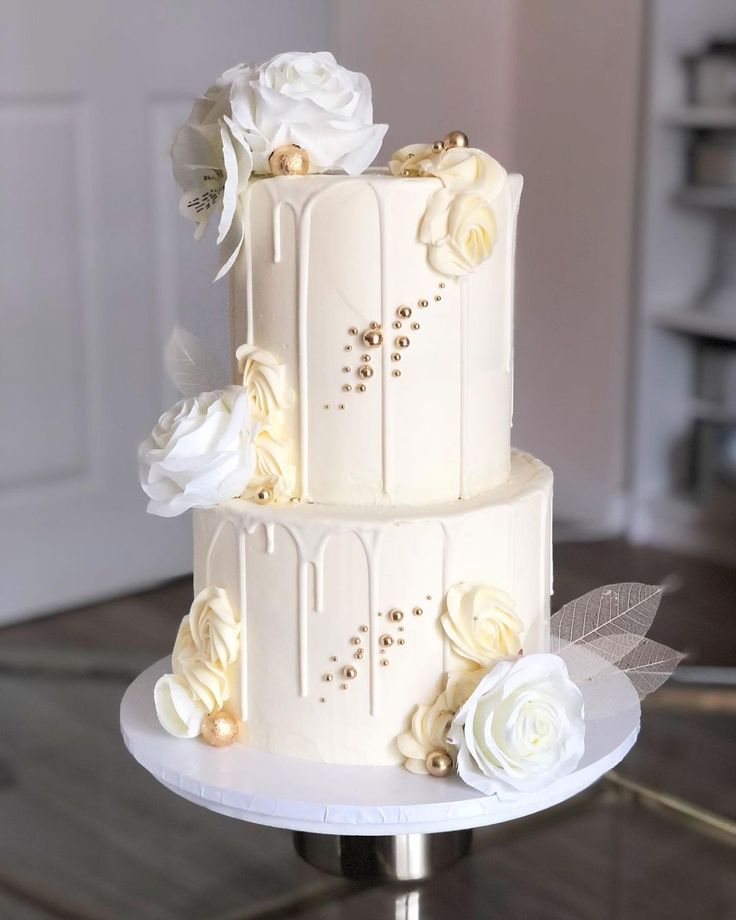 a three tiered cake with white flowers on top