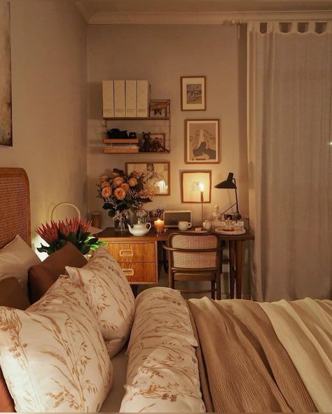 a bed sitting in a bedroom next to a desk with flowers on top of it