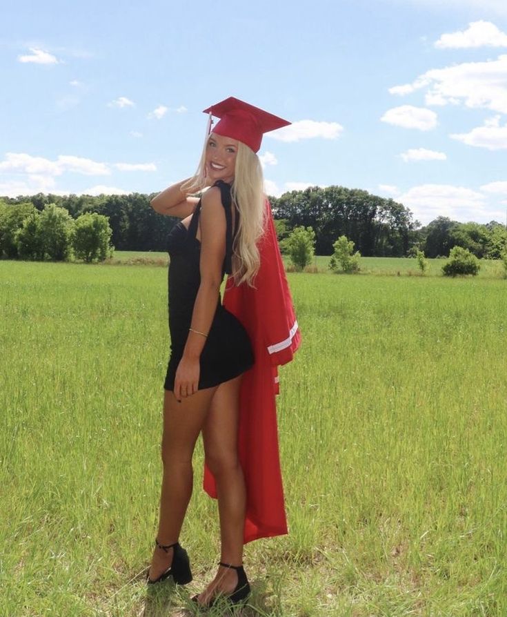 a woman in a graduation cap and gown posing for a photo with a graduate's robe on