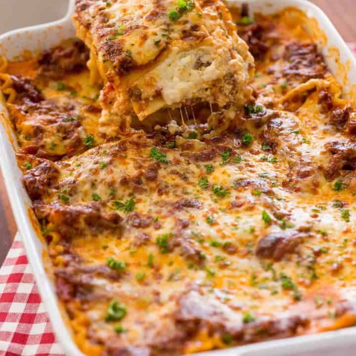 lasagna casserole with meat and cheese being lifted from the casserole dish