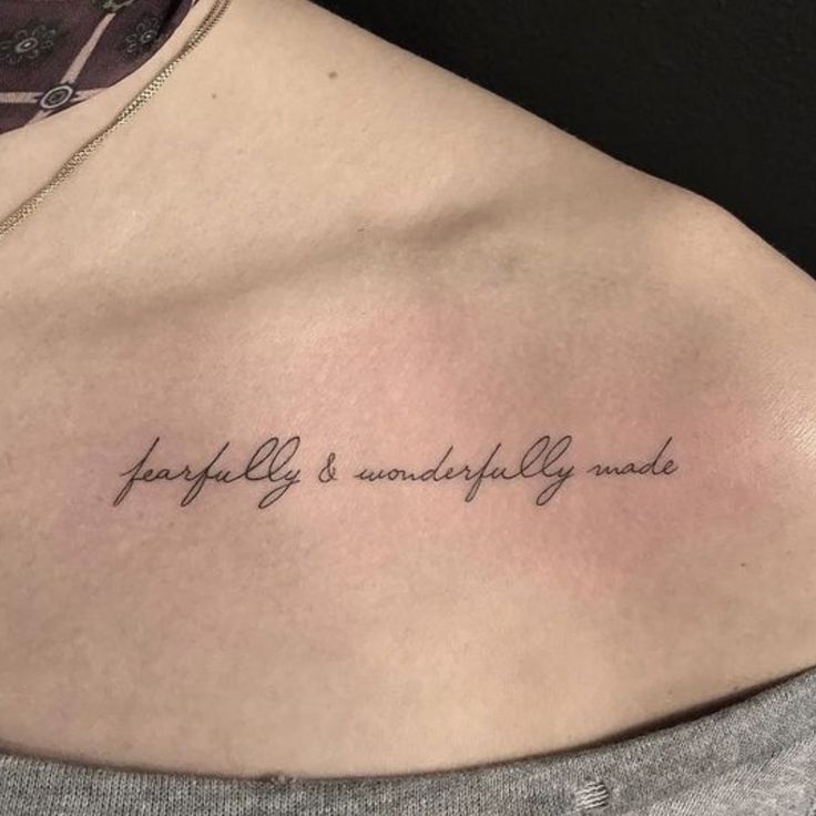 a woman with a tattoo on her chest saying, happily is wonderfully made in cursive writing