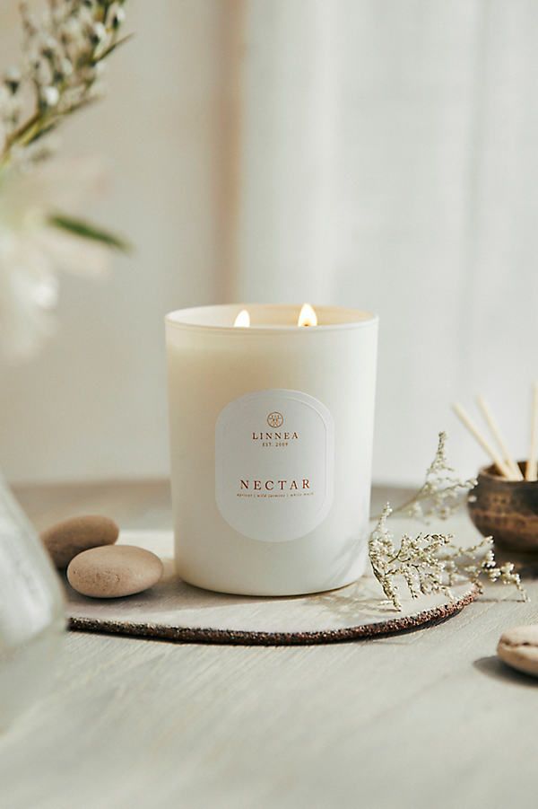 a white candle sitting on top of a wooden table