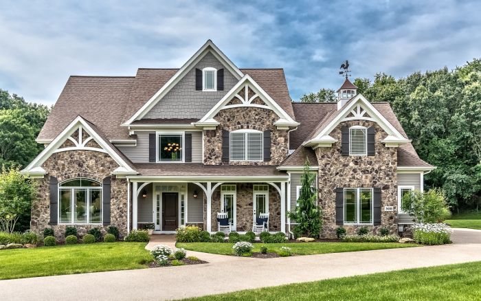 a large stone house in the middle of a lush green field