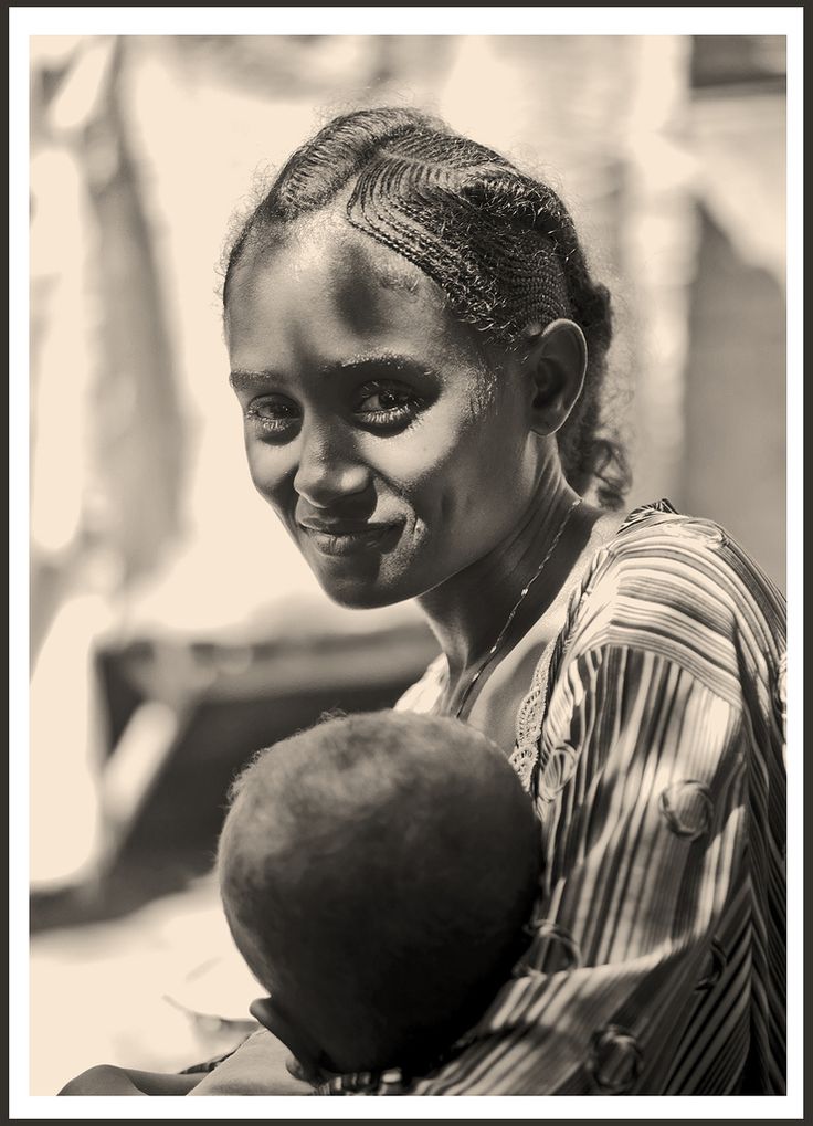 a black and white photo of a woman holding a baby