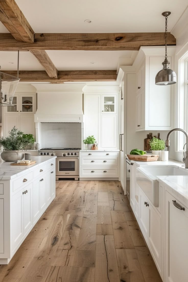 a large kitchen with white cabinets and wood flooring, along with an island in the middle