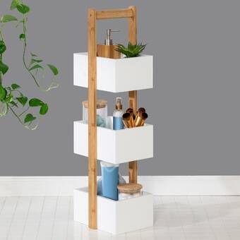 three tiered white shelf with plants in the corner next to it and a potted plant