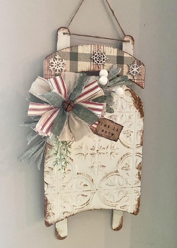 an old door hanger is decorated with bows and snowflakes