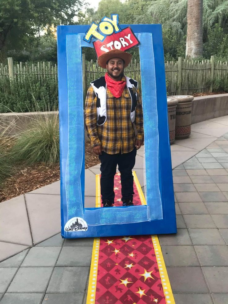 a man in a toy story costume standing on a red and yellow carpeted walkway