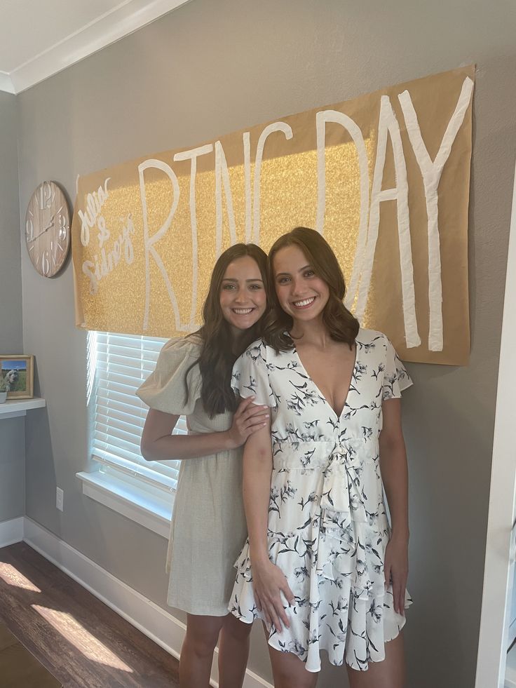 two women standing next to each other in front of a sign that says spring day