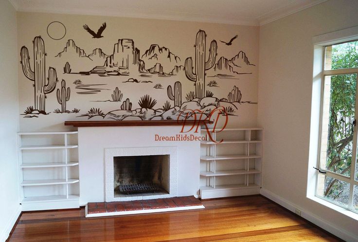 an empty living room with a fireplace and mural on the wall