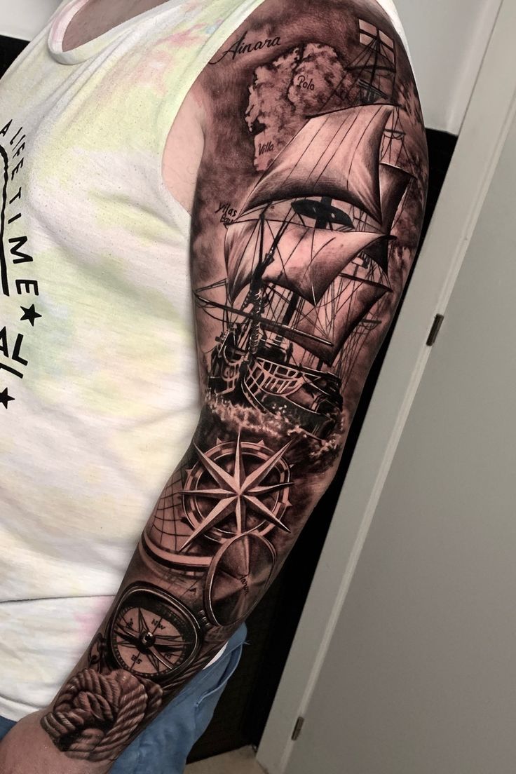 a man wearing a white shirt has a black and grey tattoo on his arm with a ship in the background