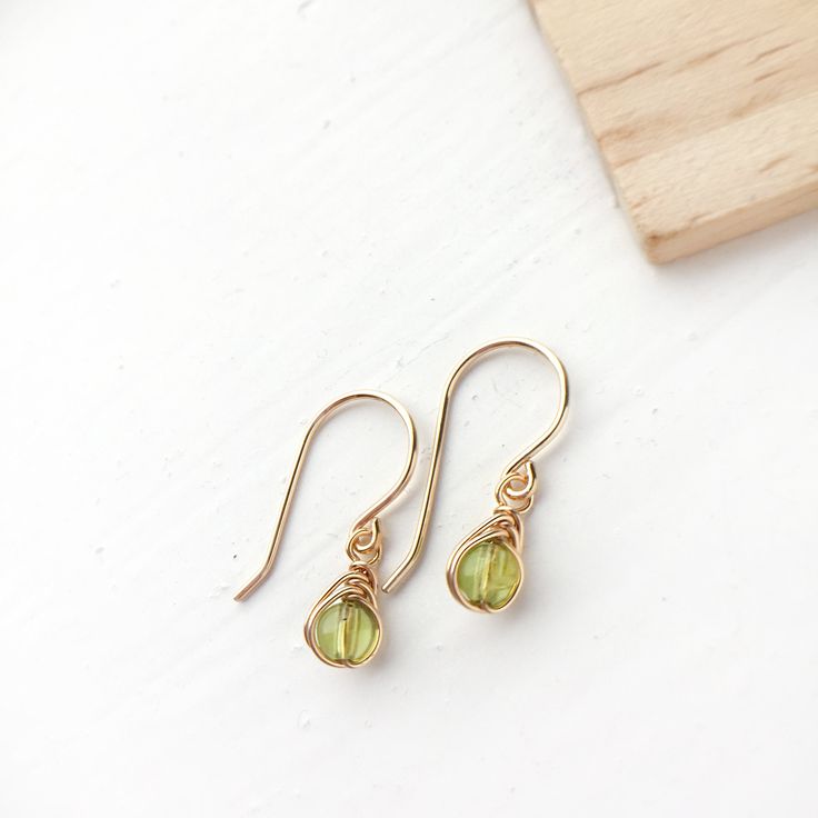 💚 Tiny Peridot dangle earrings with 4mm genuine Peridot beads and 14K gold-filled or Sterling Silver wire. ✨ Peridot, the August birthstone, is the stone of positive power. It symbolizes the sun, the source of all abundance. Peridot increases happiness, wards off negativity and keeps the mind calm ✨ * Dainty, cute and very comfortable. They are perfect for your basic everyday wear and will make a wonderful gift. Also an affordable treat for yourself :) * 14K gold-filled and sterling silver wire Gold Peridot Gemstone Earrings, Dainty Earrings For Jewelry Making With May Birthstone, Yellow Gold Peridot Earrings For Gift, Peridot Dangle Earrings Gift, Gold Peridot Earrings For May Birthstone, Delicate Wire Wrapped Yellow Gold Earrings, Nickel-free Yellow Gold Briolette Earrings, Nickel-free Briolette Yellow Gold Earrings, Delicate Yellow Gold Wire Wrapped Earrings