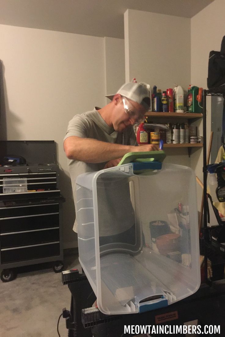 a man working on an open refrigerator in his garage