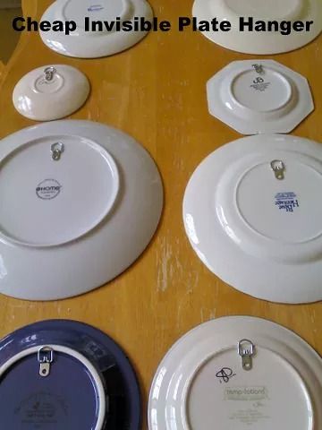 there are many plates on the table with tags attached to them and one has a tag that says cheap invisible plate hanger