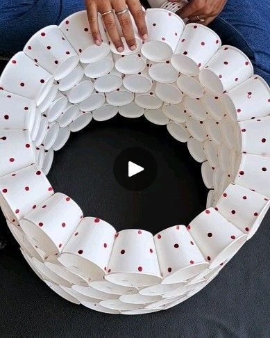 a woman holding a white plate with red dots on it