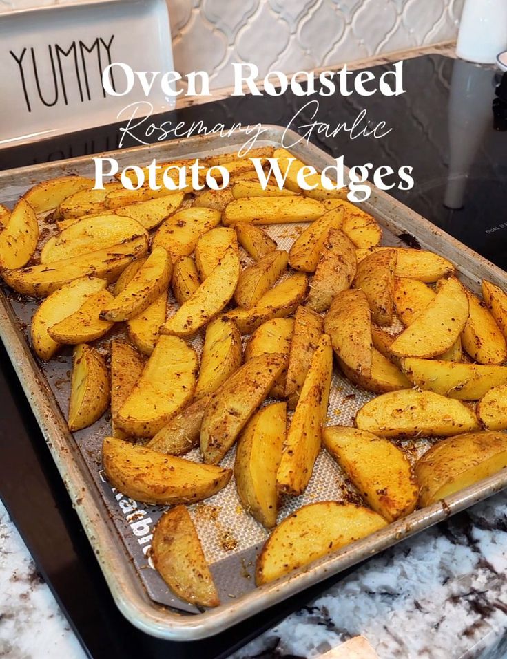 baked potato wedges sitting on top of a baking sheet in an oven with the words, oven roasted rosemary garlic potatoes