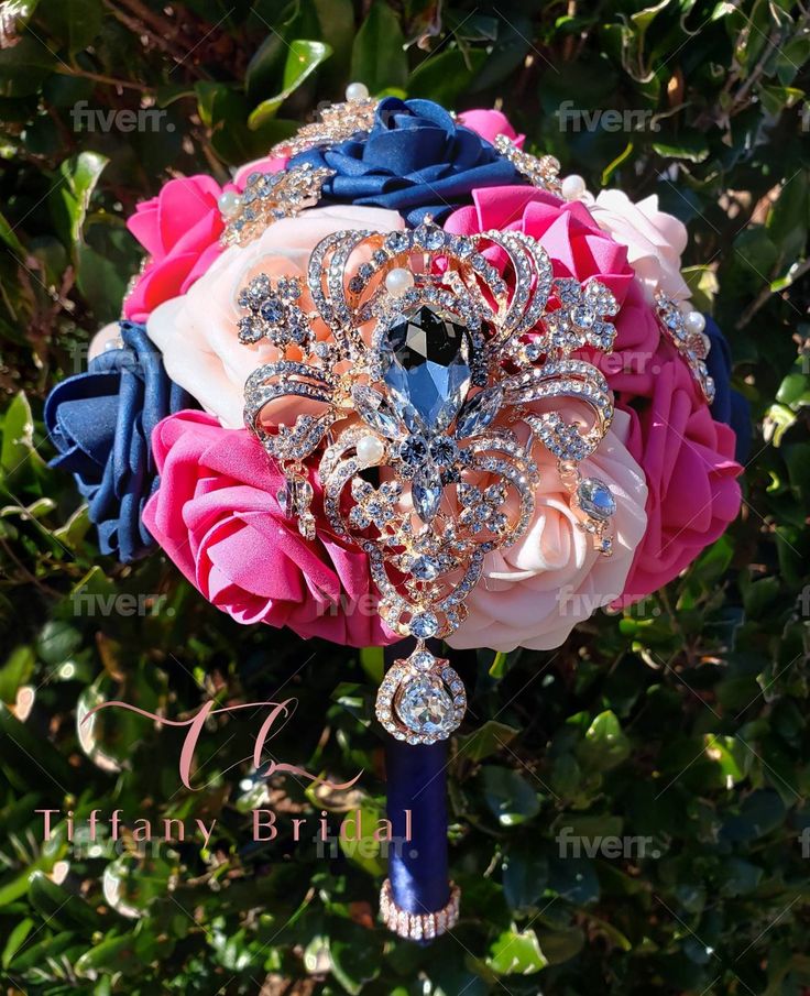 a bridal bouquet with brooches and jewels on it in front of some bushes